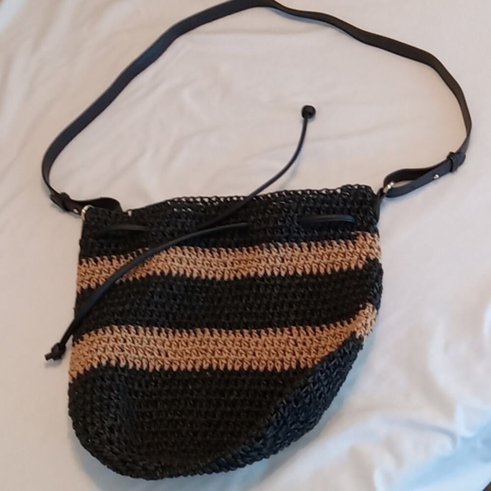 Black and tan straw draw string purse.